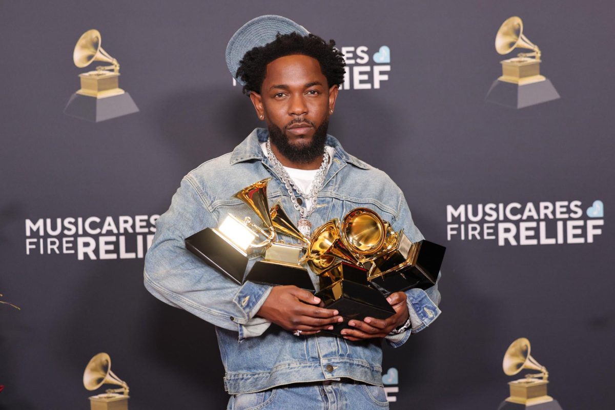 Kendrick Lamar posing with his five Grammys for "Not Like Us," his diss track on Drake.